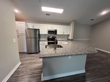 A kitchen with granite counter top and stainless steel appliances